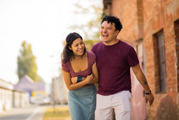 happy laughing couple walking down street