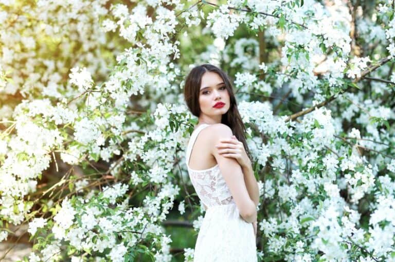 Young beautiful woman in spring blossom trees.