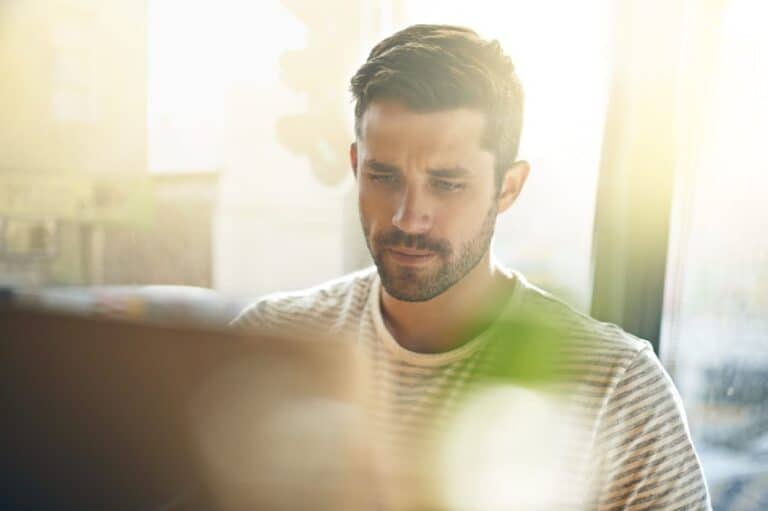 Handsome young man with beard on laptop