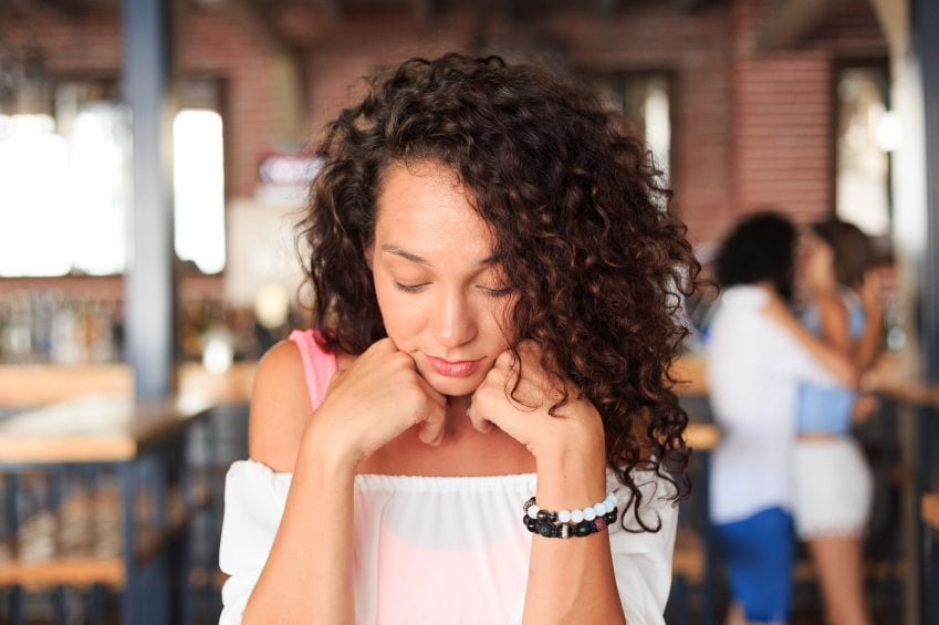 Curly haired woman sitting sad