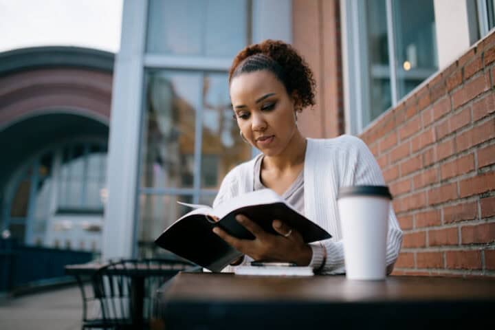 woman reading book at cafe
