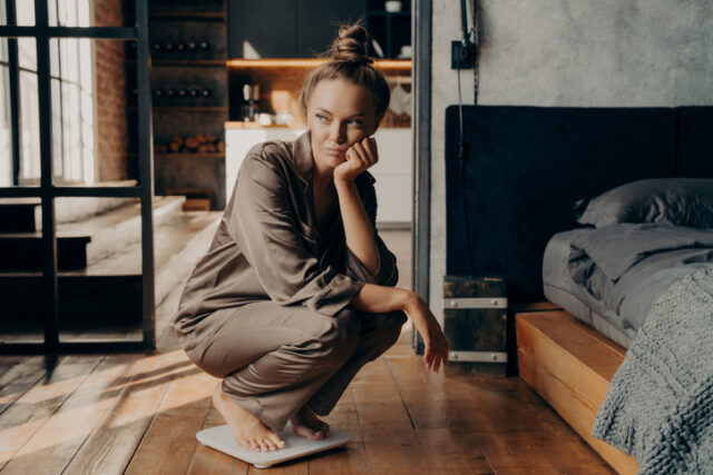 young woman crouching on scale