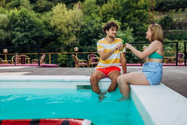 couple having beer poolside