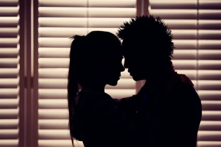 Couple in dark against blinds