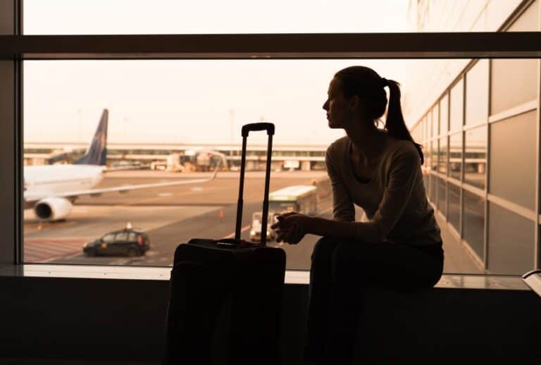 Woman with suitcase at airport.
