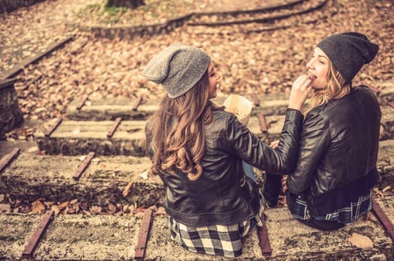 Two girls sat amongst leaves