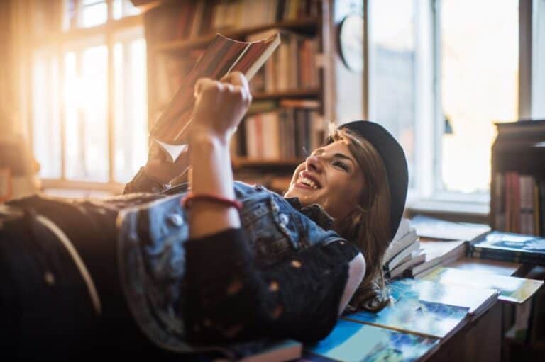 Happy woman lying on bookd smiling