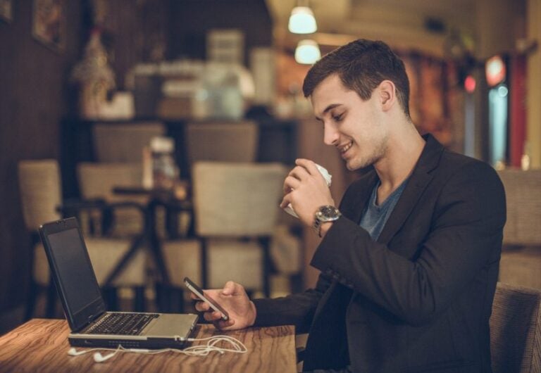 man sitting in a cafe texting
