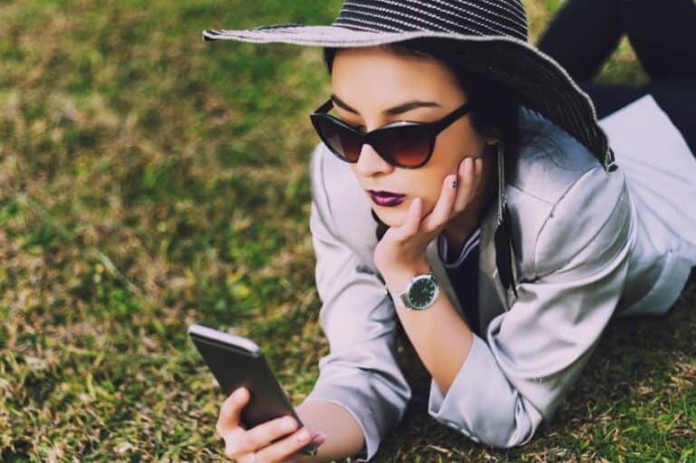 Young woman with hat on smartphone