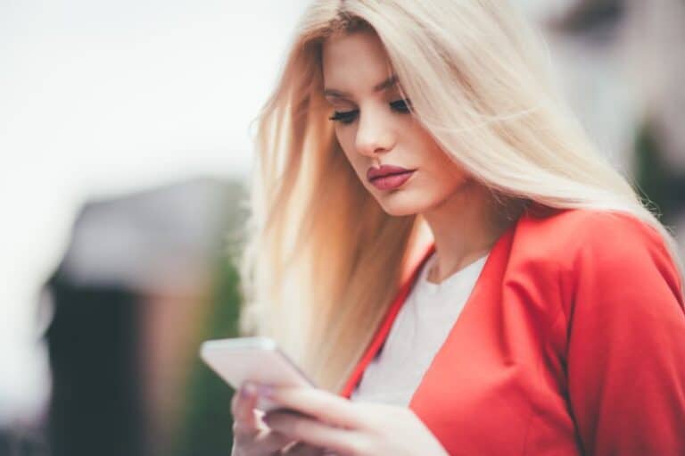 Woman in red looking at her mobile.