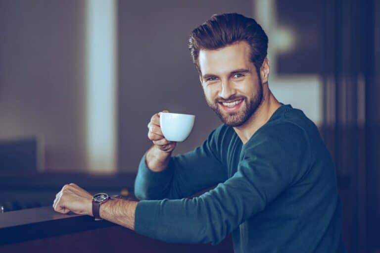 Handsome young man with beard and coffee cup