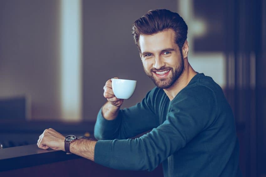 Handsome young man with beard and coffee cup