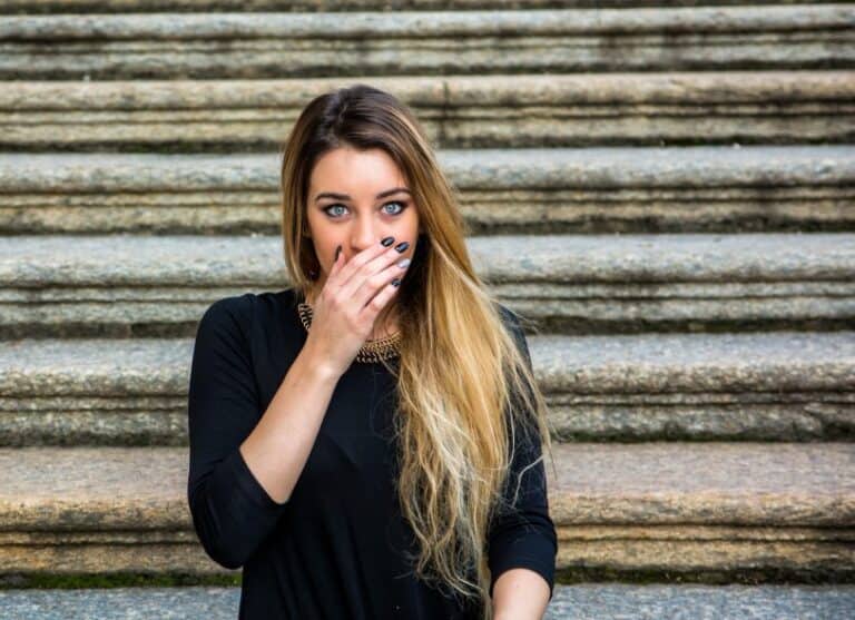 Young woman covering her mouth in shock