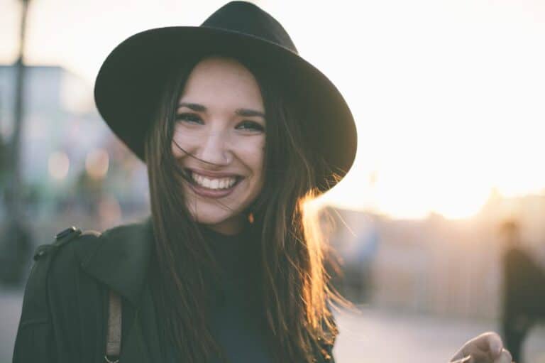Brunette standing with hat