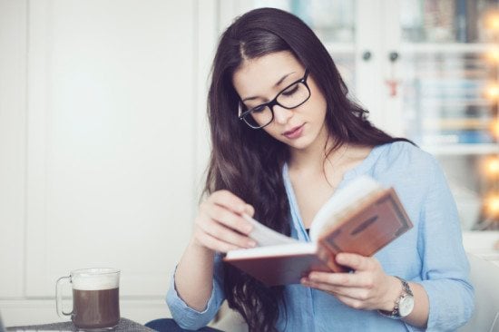 woman drinking coffee reading book