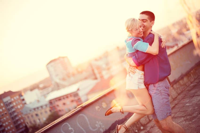happy couple embracing on rooftop