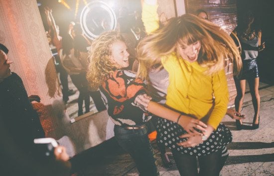 Female friends dancing at a party.