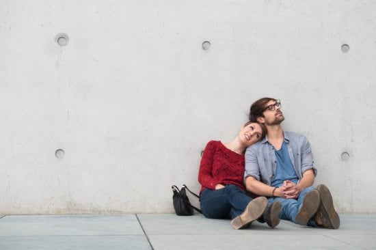 couple sitting against wall outdoors