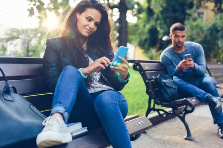 couple park benches texting