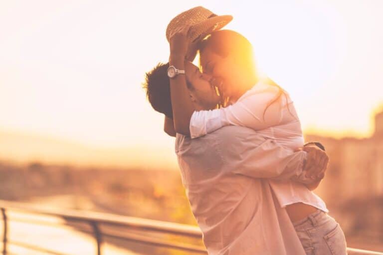 couple embracing sunset water