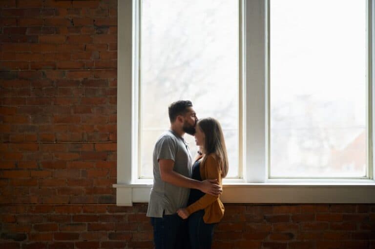 man kissing woman's head