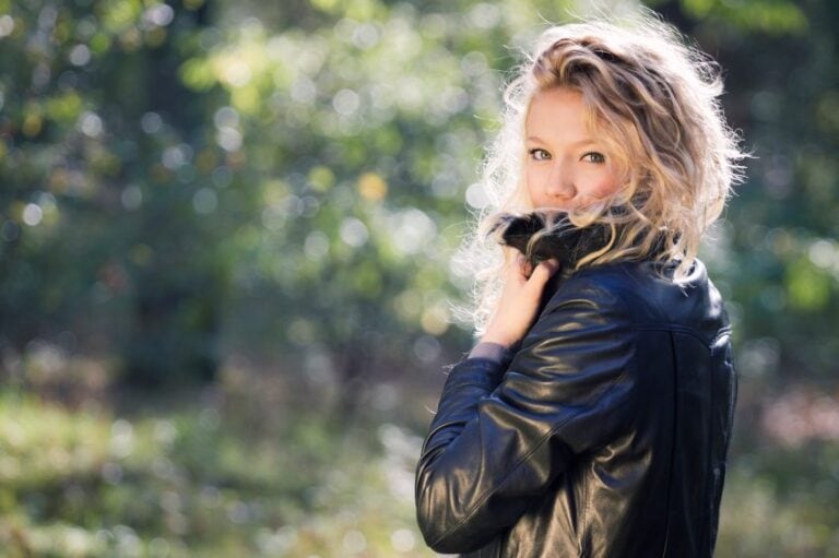 woman jacket green trees sun