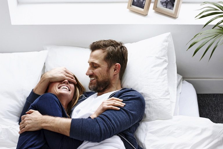 couple smiling bed happy