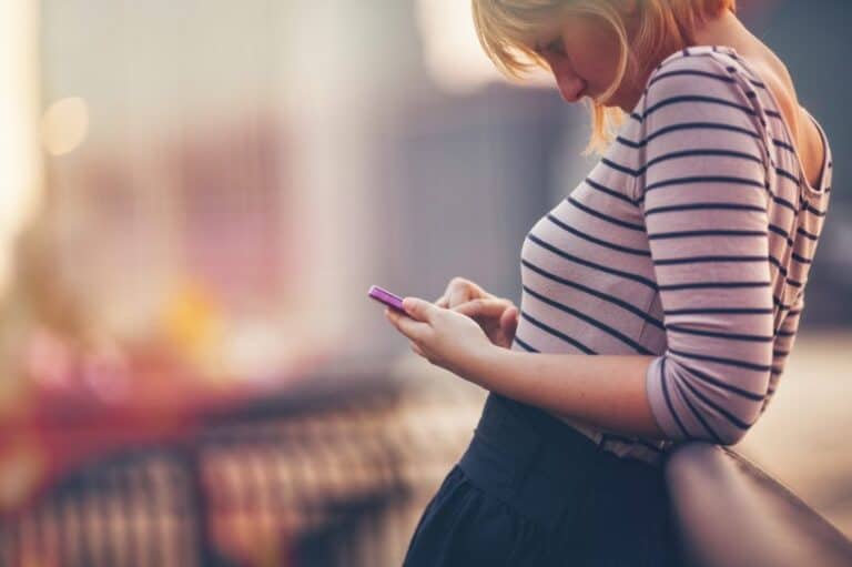 woman texting phone sun