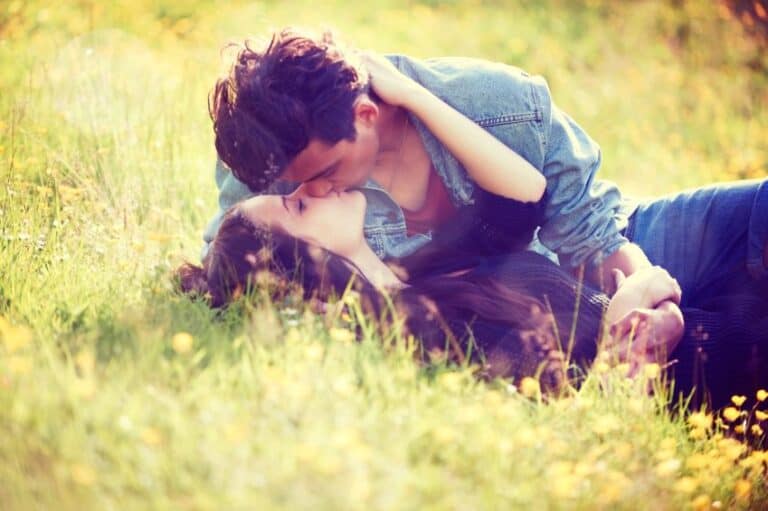couple kissing field flowers