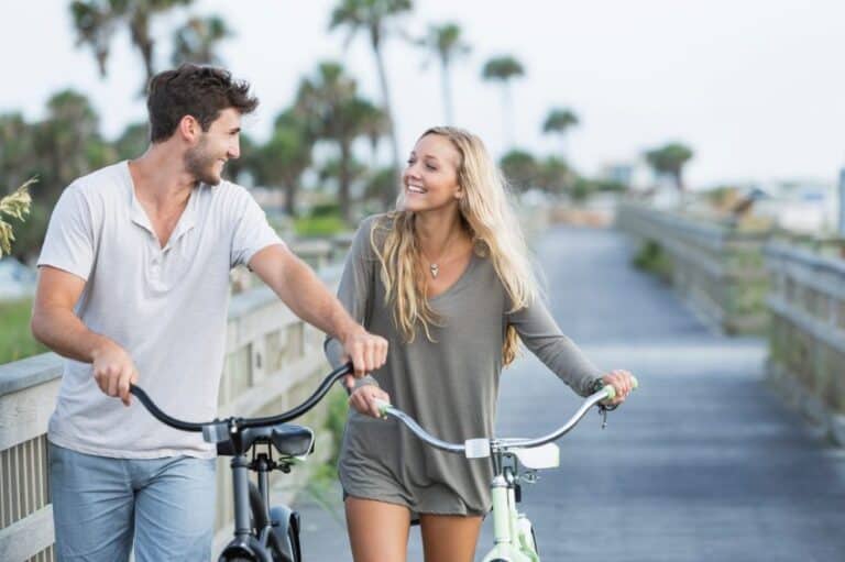 couple happy bikes palm trees