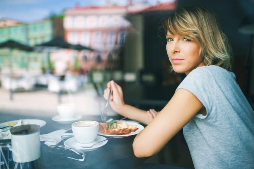 Woman eating alone at a restaurant.
