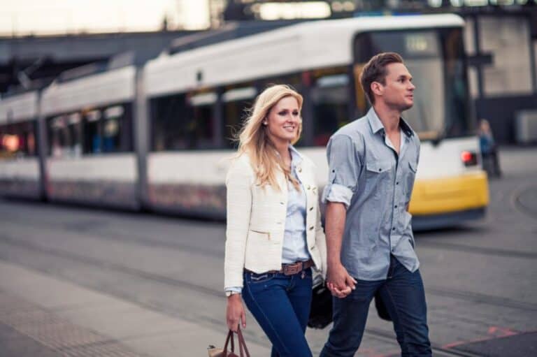 man woman holding hands bus city