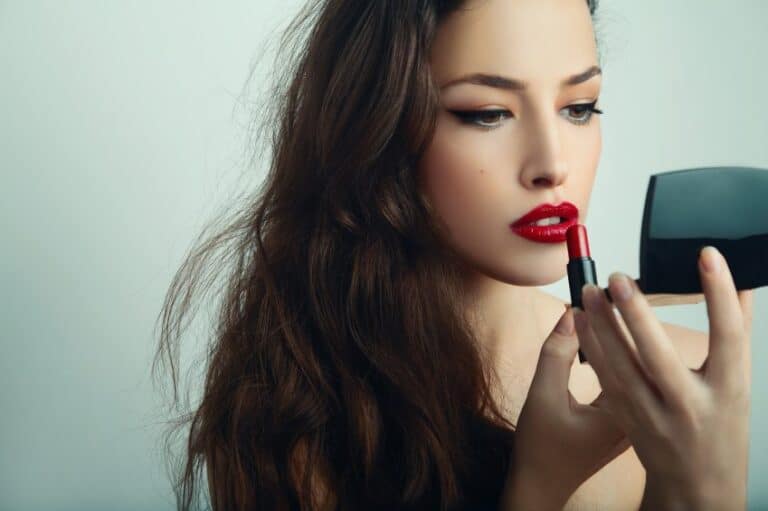 Woman applying lipstick.