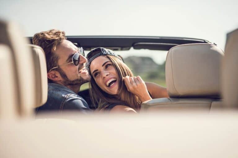 couple laughing in convertible car