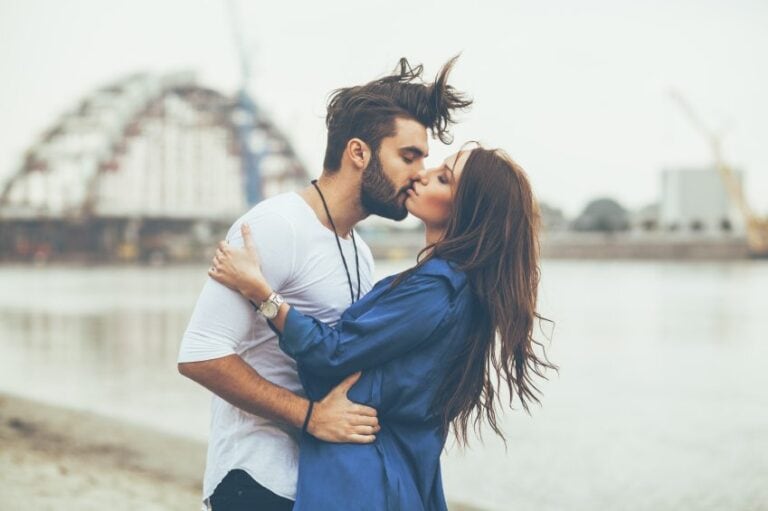 couple kissing bridge
