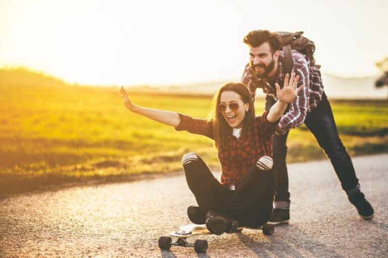 man woman friends sun skateboard