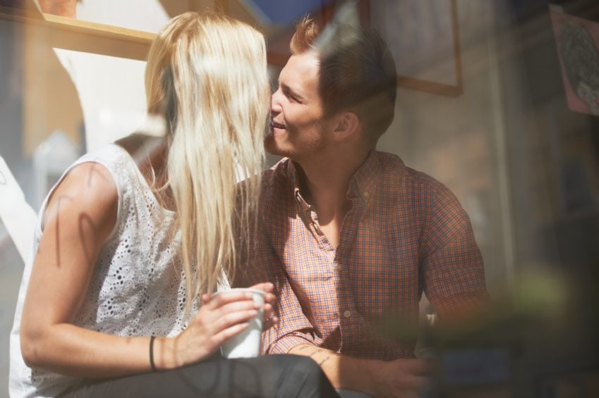 A loving young couple kissing in a cafe