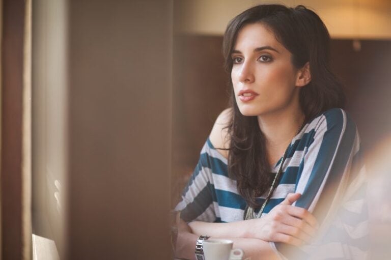 Young woman sitting alone at a cafe.