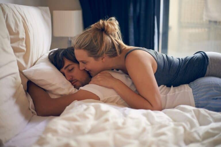 Couple in bed kissing