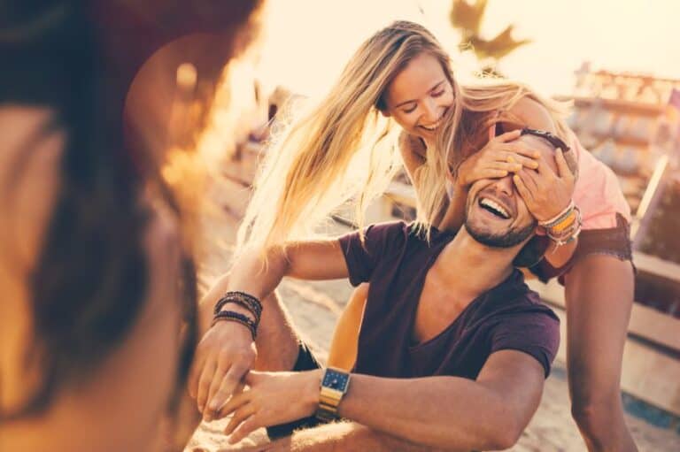 Girl surprises guy at on the beach