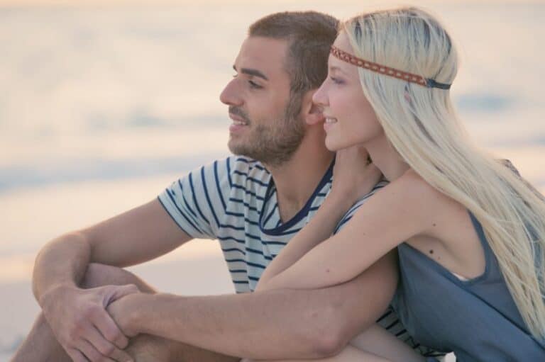 Young couple sat on beach
