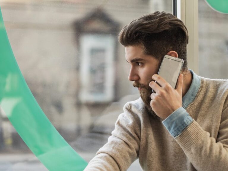 Hipster man talking on mobile phone by the window.
