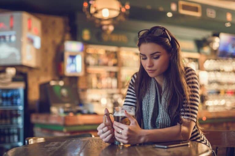 Lonely young woman sitting in a bar and thinking.