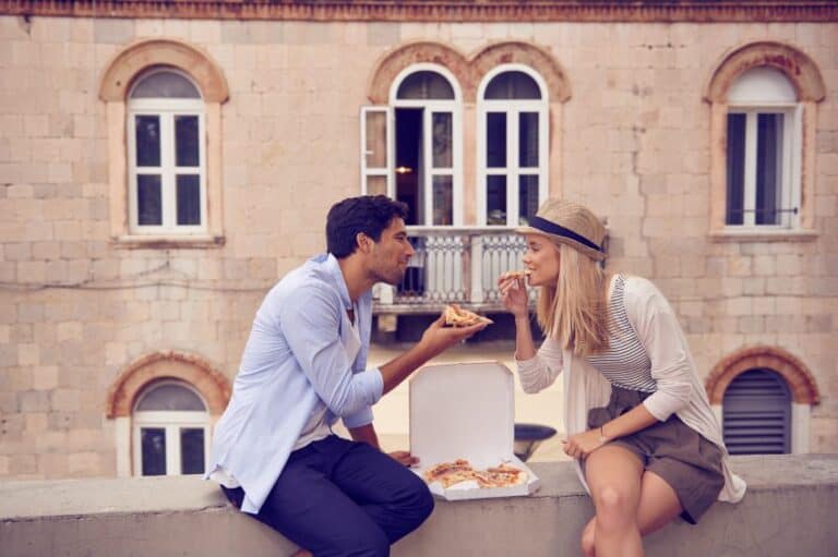 Young adult couple eating pizza