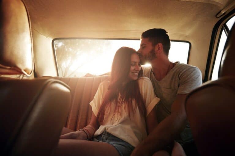 Young couple kissing in the back of car