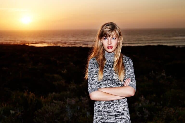 beautiful young woman arms crossed sunset