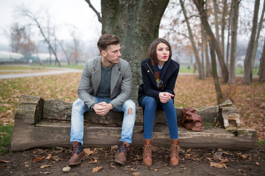 Young couple sitting outside having problems