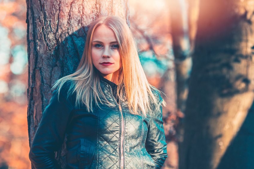 Blonde resting on tree outdoors