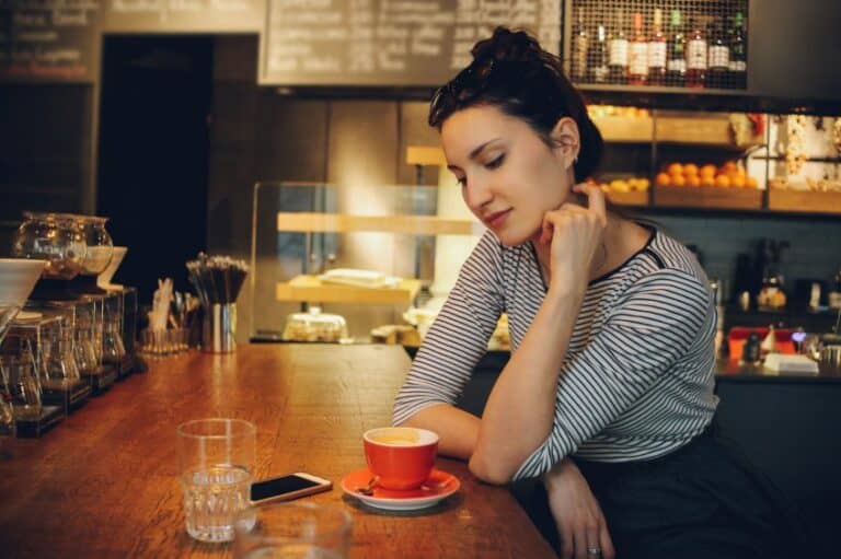 Young woman sat cafe alone