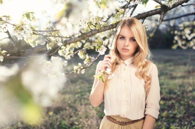 woman serious trees flowers